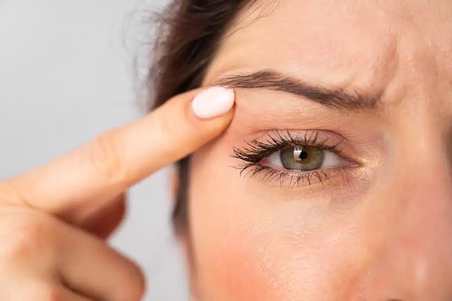 woman looking at her droopy eyelids