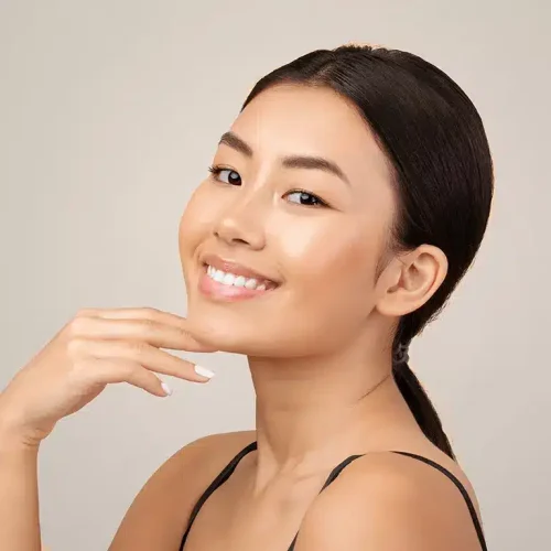 woman smiling touching chin with clear skin